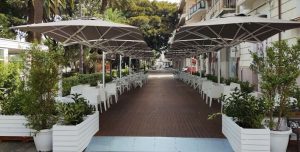 Dual V Starwhite 2-Way Side-Arm Parasol in outdoor restaurant scene